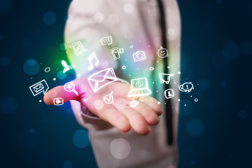 Obraz premium Young businessman presenting colorful glowing social media icons