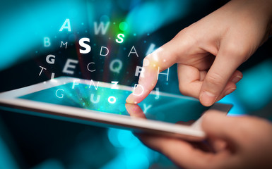 Finger pointing on tablet pc, letters concept
