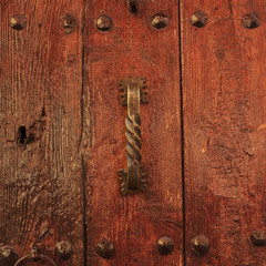 Varnished wooden door with antique doorhandle