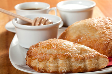 Breakfast including coffee, bread, honey.