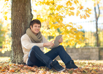 man with tablet pc in autumn park