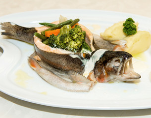 Steamed  trout with vegetables on white dish