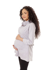 A pregnant woman cradles her baby bump through a maternity shirt