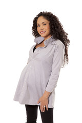A pregnant woman flashes a big smile in her maternity shirt.
