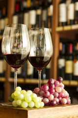 Copas de Vino tinto, botellas y uvas. Vineria vinoteca.