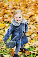 Cute little girl playing in autumn park