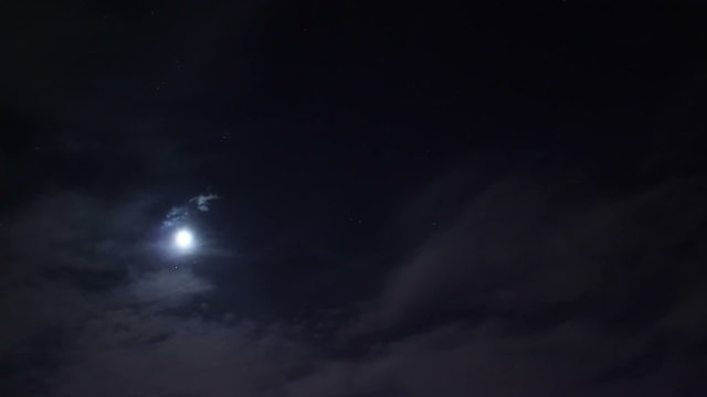 Night moon sky timelapse, clouds move pass dark, stars shine