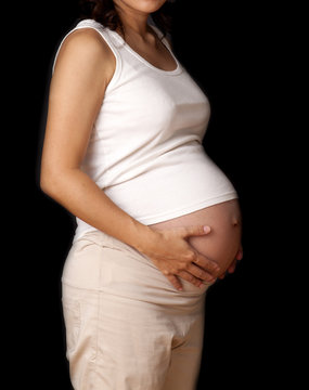 Pregnant woman with hands over tummy.