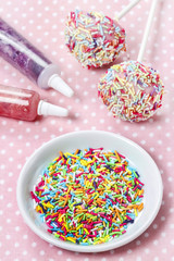 Decorating cake pops with colorful sprinkles