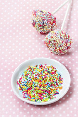 Decorating cake pops with colorful sprinkles