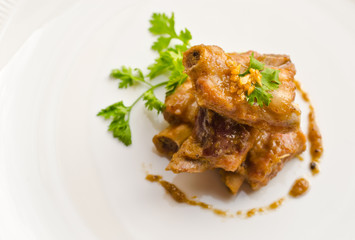 Close up pork rib roast with sauce on a white plate