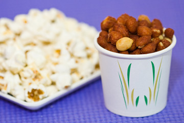 Roasted Peanut in cup and popcorn as background
