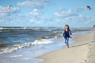 Adorable little girl playing on the beach