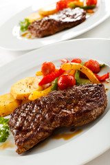 Grilled beefsteak, baked potatoes and vegetables