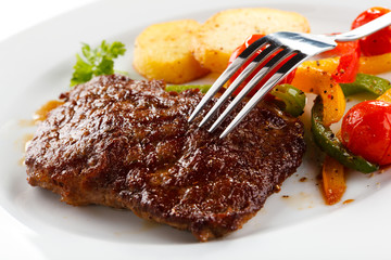 Grilled beefsteak, baked potatoes and vegetables