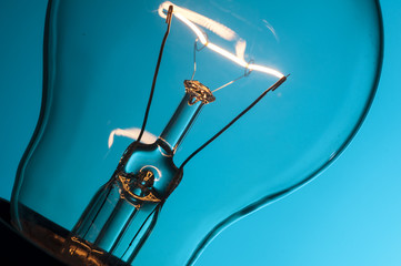 Close up glowing light bulb on blue background