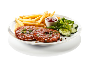 Grilled steaks, French fries and vegetables