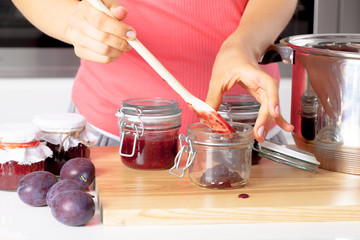 Putting fresh jams into a jars
