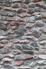 Old gray rough stone wall. Vertical background photo texture