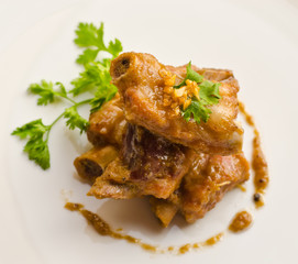 Close up pork rib roast with sauce on a white plate