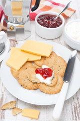 Breakfast with crackers, cheese, cream and berry jam
