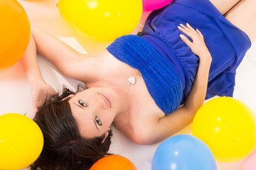 Obraz na płótnie Canvas sexy young woman lying on floor among balloons