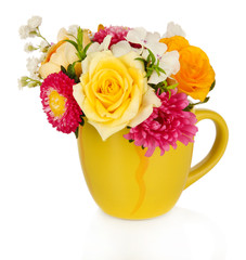 Beautiful bouquet of bright flowers in color mug, isolated