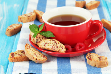 Cup of tea with cookies and raspberries on table close-up
