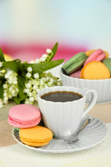 Coffee and macaroons on table on light background