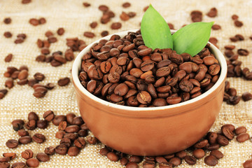 Coffee beans in bowl on table close-up