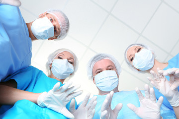 View from below of surgeons in protective work wear during