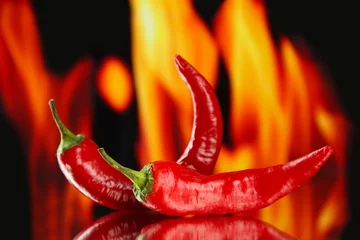 Rolgordijnen Red hot chili peppers on fire background © Africa Studio