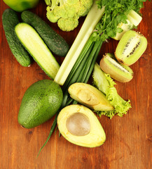 Fresh green vegetables and fruits, on wooden background