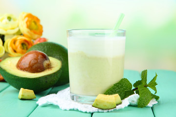 Fresh avocado smoothie on bright background