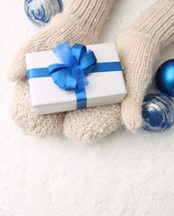 Female hands  in mittens with gift box, on white background