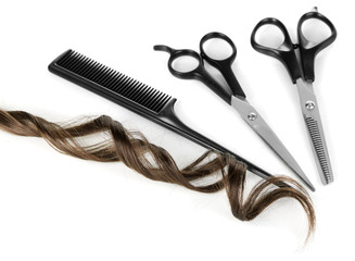 Shiny brown curl with scissors and comb isolated on white