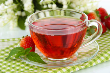Delicious strawberry tea on table close-up