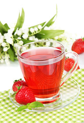 Delicious strawberry tea on table on white background