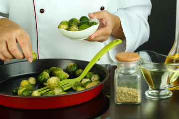 Chef prepares frresh brussels sprouts in pan