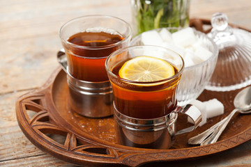 Set of cups with black tea on tray