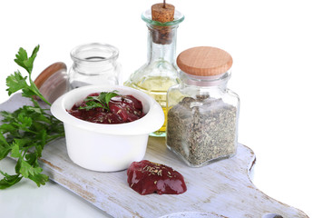 Raw liver in bowl with spices and condiments isolated on white