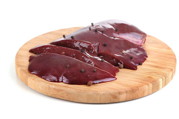 Raw liver on wooden board isolated on white