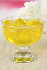 Tasty jelly cubes in bowl on table on light background