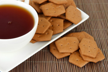 Chocolate crackers with cup of tea on bamboo background