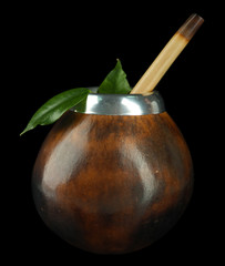 Calabash and bombilla with yerba mate isolated on black