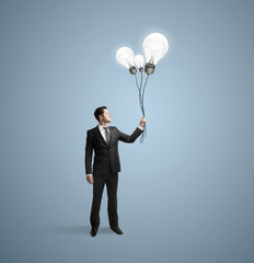 businessman holding bulbs