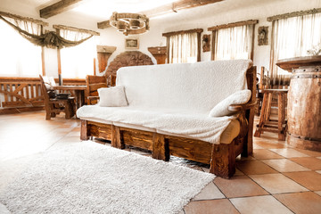 Big wooden sofa with white blanket in living room
