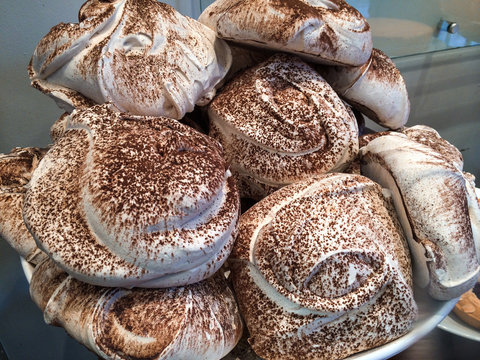 Colourful tasty meringues with chocolate powder