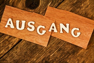 das Wort AUSGANG auf Holztafel
