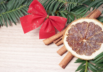 Tannenzweig mit Zimtstangen und Orangenscheibe